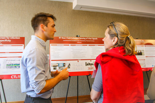 Two people talking in front of posters